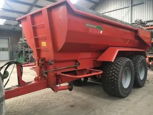 Rode grondkar achter een trekker