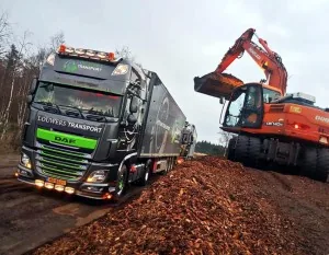 Vrachtwagen met een graafmachine op de achtergrond